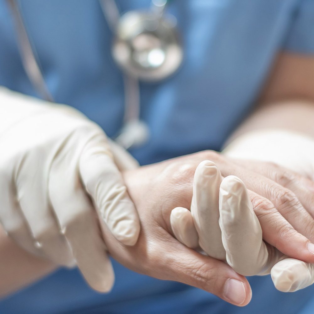 Anästhesist hält Hand von Patienten